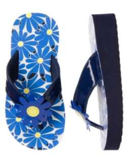 Navy blue flip flops have bright blue and white daisy print with shiny 