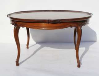 style walnut coffee table, circa 1920s, with slightly shaped circular 