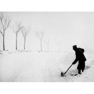  Soldier with a Shovel Removing Snow from the Edge of a 